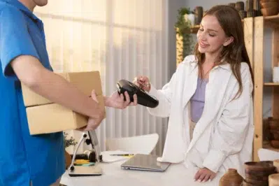 Empreendedora realiza pagamento por maquininha enquanto avalia valores previstos no simulador de vendas com taxas de antecipação no Asaas.