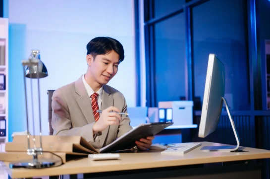 Empresário sentado em sua mesa estudando como migrar de MEI para ME.