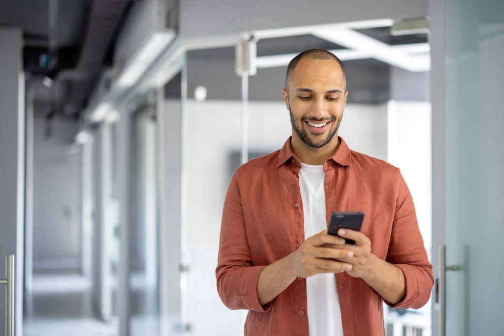 Empresário sorrindo pois seus clientes podem usar o novo recurso Pix Open Finance Asaas