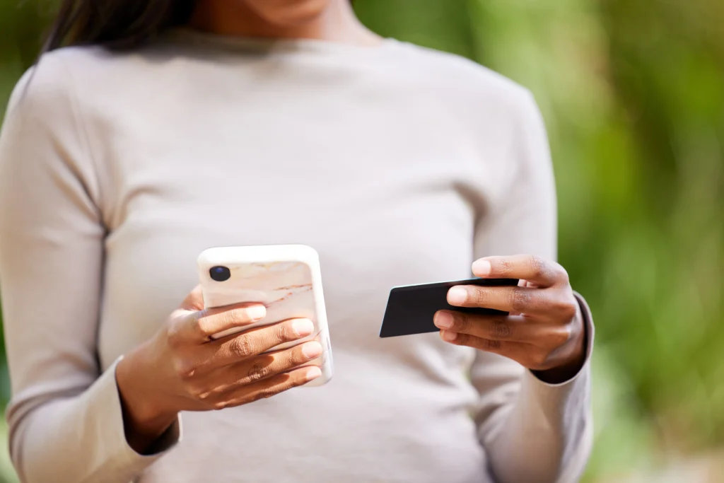 Pessoa usando celular para pagamento por aproximação enquanto busca qual aplicativo de Tap to Pay é o mais recomendado.