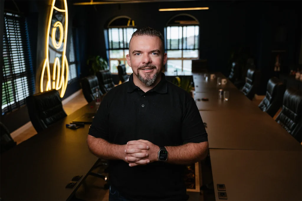 Startups entrevista Diego Contezini, representado na foto enquanto sorri e usa uma camisa polo preta.