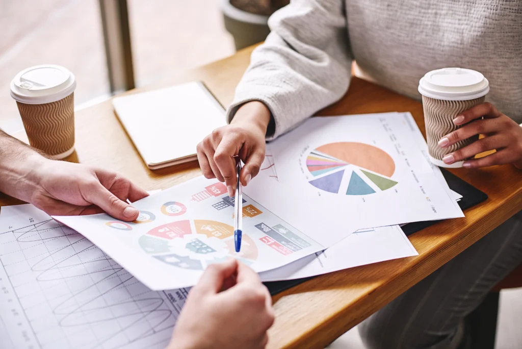 Pessoas analisando gráficos de empresas de SC que movimentaram R$ 2,7 bi em 2026.